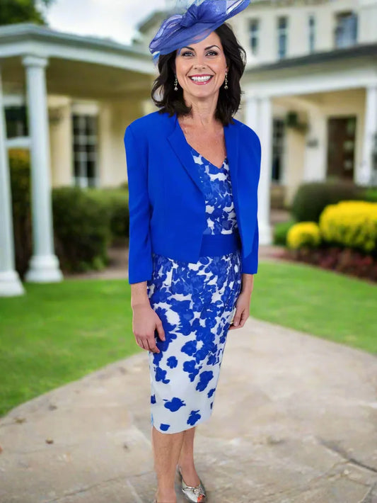 Woman wearing a blue floral dress with a matching jacket and hat on a white background