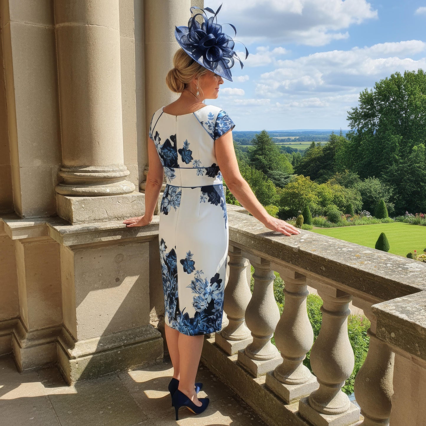 Sophisticated Condici 70820 navy outfit with ruched detailing and a tailored jacket, modelled on a terrace with sweeping views of landscaped grounds.
