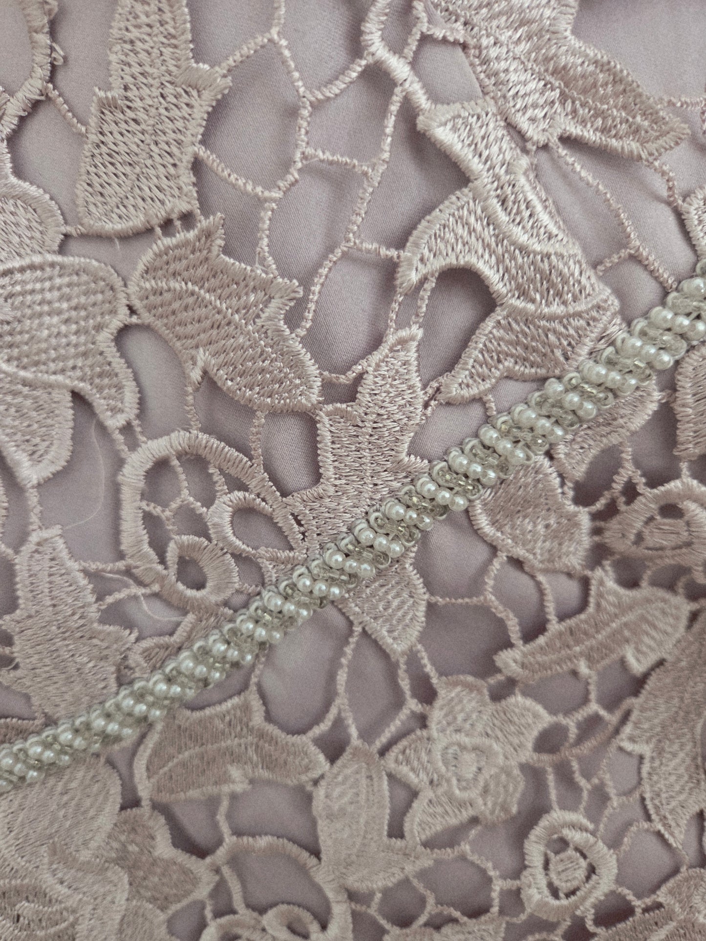 Close up detail of the beading detail on a mauve mother of the bride dress.