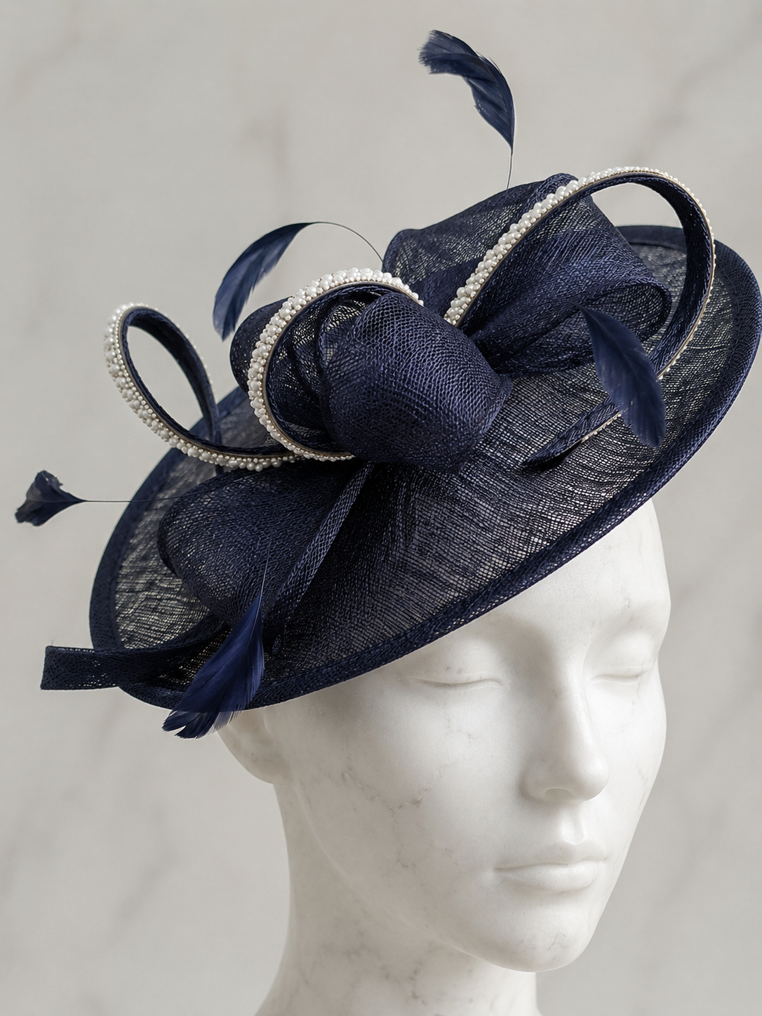 manequinn wearing a navy sparkly embellished fascinator head piece at a wedding