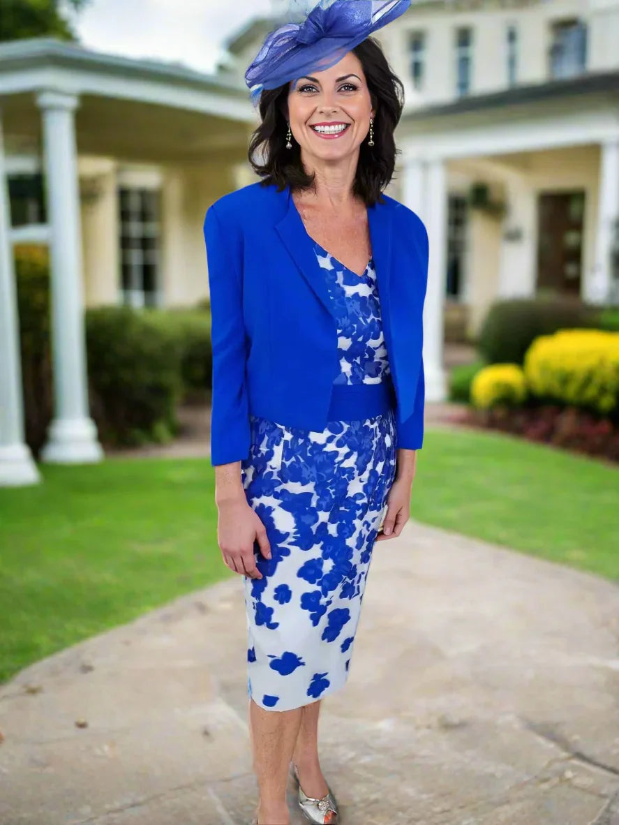 Woman wearing a blue floral dress with a matching jacket and hat on a white background
