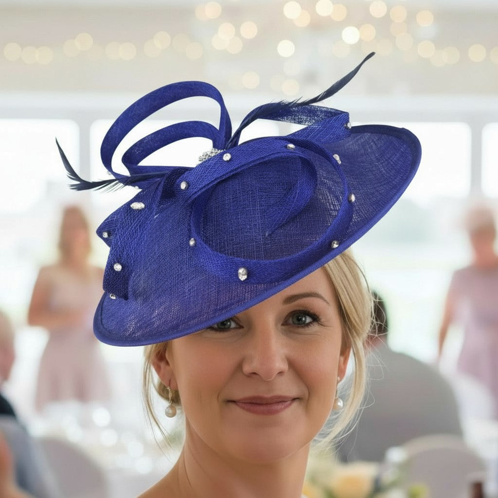 Woman wearing a cobalt blue embellished fascinator hat with feathers in an indoor setting