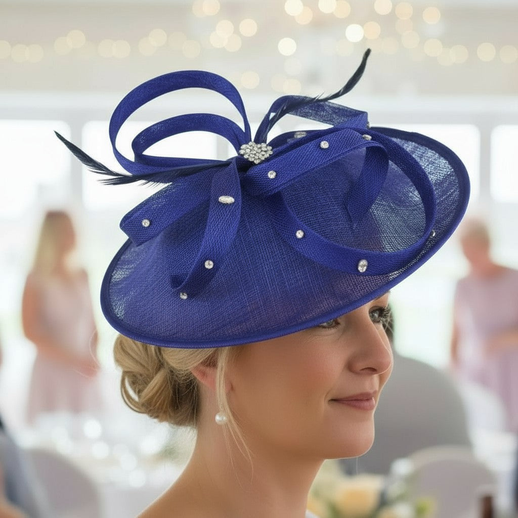 Woman wearing a cobalt blue embellished fascinator hat with feathers in an indoor setting