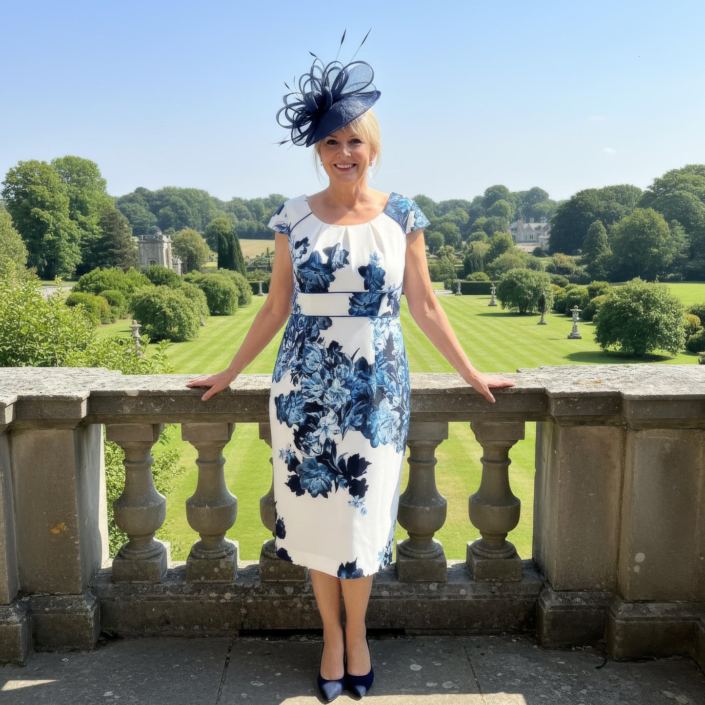 Navy Condici 70820 Mother of the Bride ensemble photographed against a formal garden backdrop, showcasing the structured jacket and flattering knee‑length dress