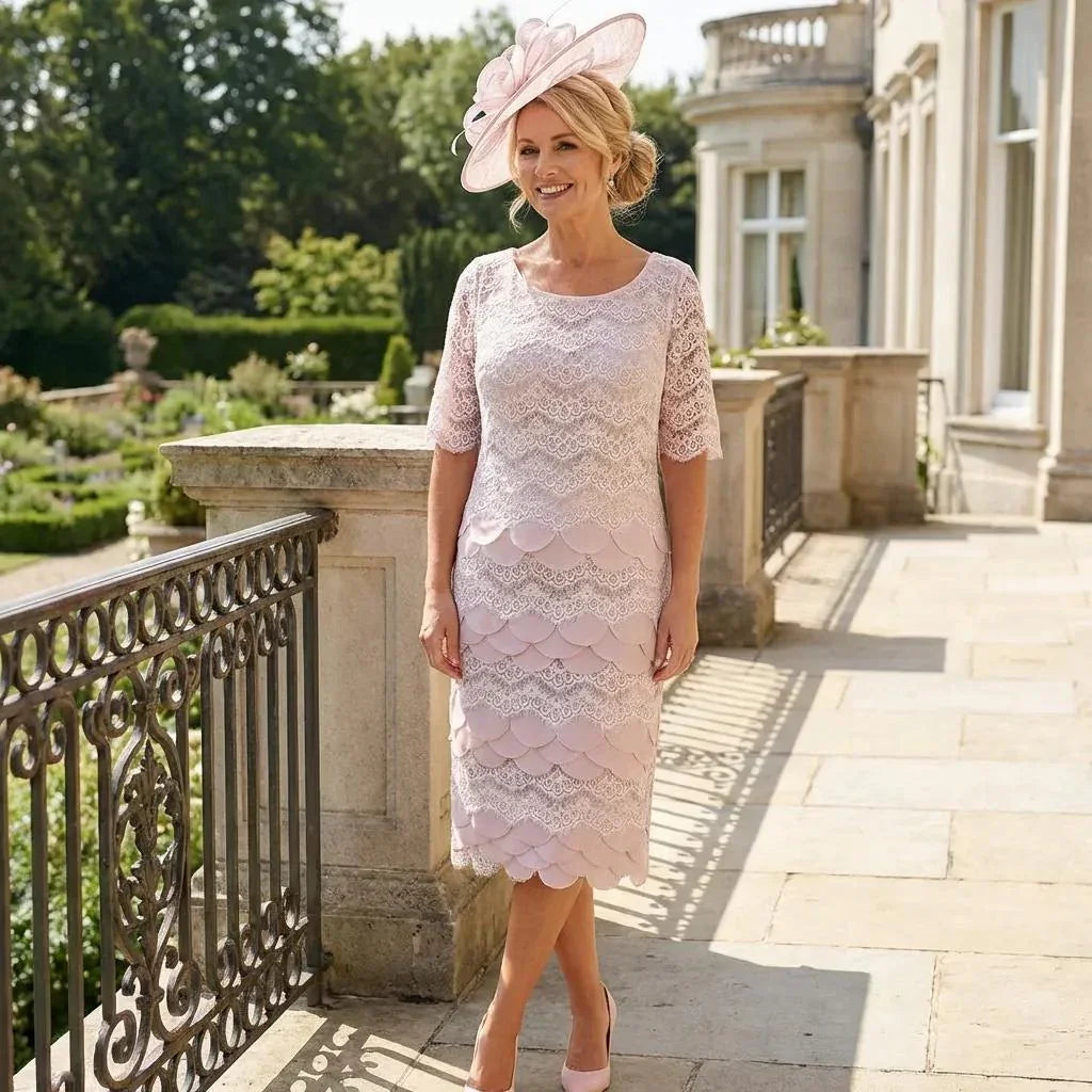 Woman in a Condici pink mother of the dress and jacket and a matching pink fascinator ready for a wedding. Signature Dress