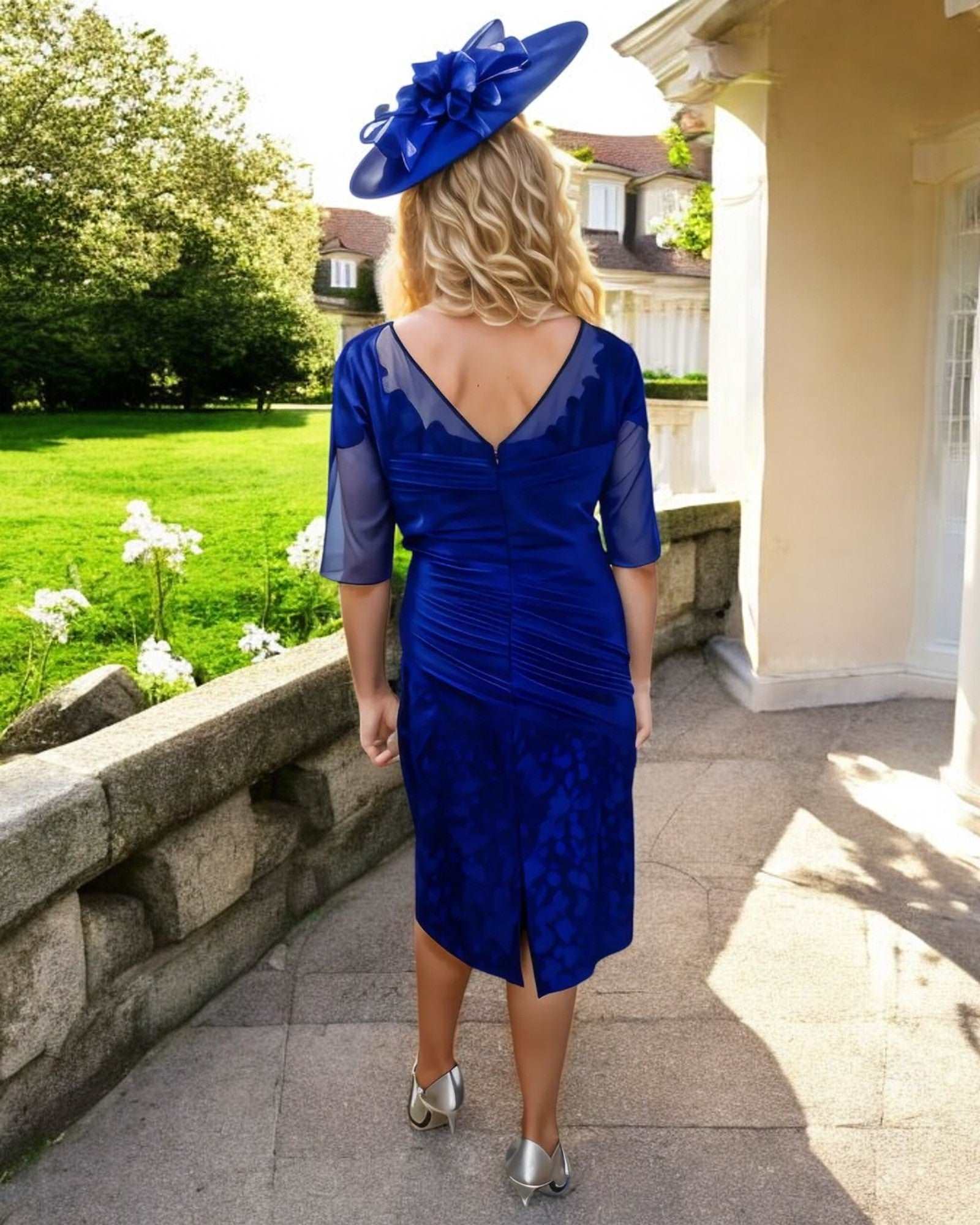 Rich Hydrangea.Embellished lace detailing to round necklineElbow length sleevesRuched throughout the bodice and skirt with contrasting lace appliqueSits just below the knee.