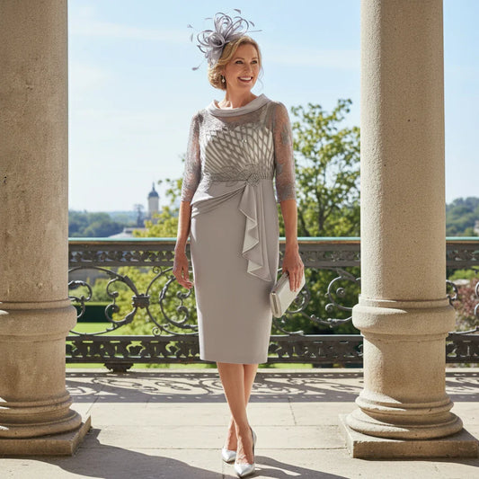 Woman in a light taupe Couture Club Mother of the Bride dress standing on a balcony ready to attend a wedding