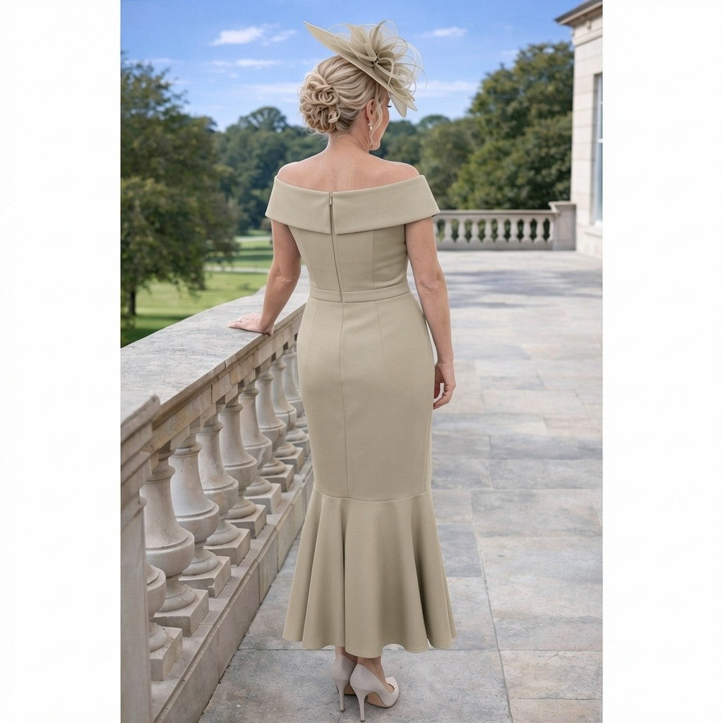 Taupe hi‑lo mother of the bride dress with off‑the‑shoulder Bardot neckline, fitted waist and dramatic frill hem, worn outdoors with matching hat and heels.