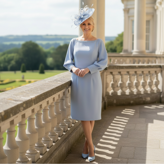 Woman wearing a John Charles blue mother of the dress ith sleeves, she is wearing a matching light blue fascinator to a wedding. Signature Dress.