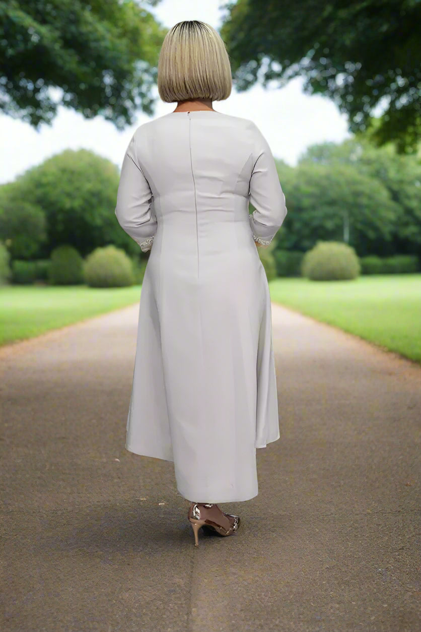 The Lizabella Dress With Neck and Sleeve Pearl Detail is a stunning and sophisticated dress that features a classic design with unique and elegant details.