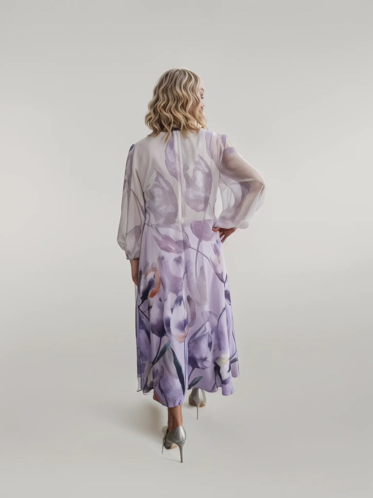 A beautiful dress in purple floral chiffon fabric.  The A line dress has a draped neckline with full 3/4 sleeves. a perfect dress for the mother of the bride.