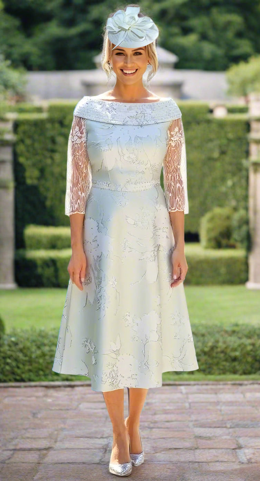 Woman wearing a light blue and white lace dress with a matching headpiece on a white background