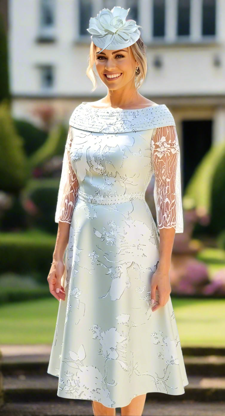 Woman wearing a mint green lace dress with a matching headpiece at a wedding