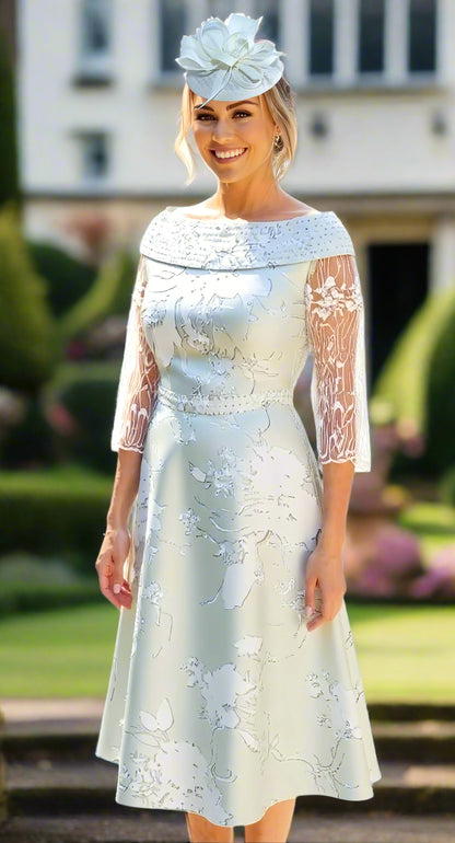Woman wearing a mint green lace dress with a matching headpiece at a wedding