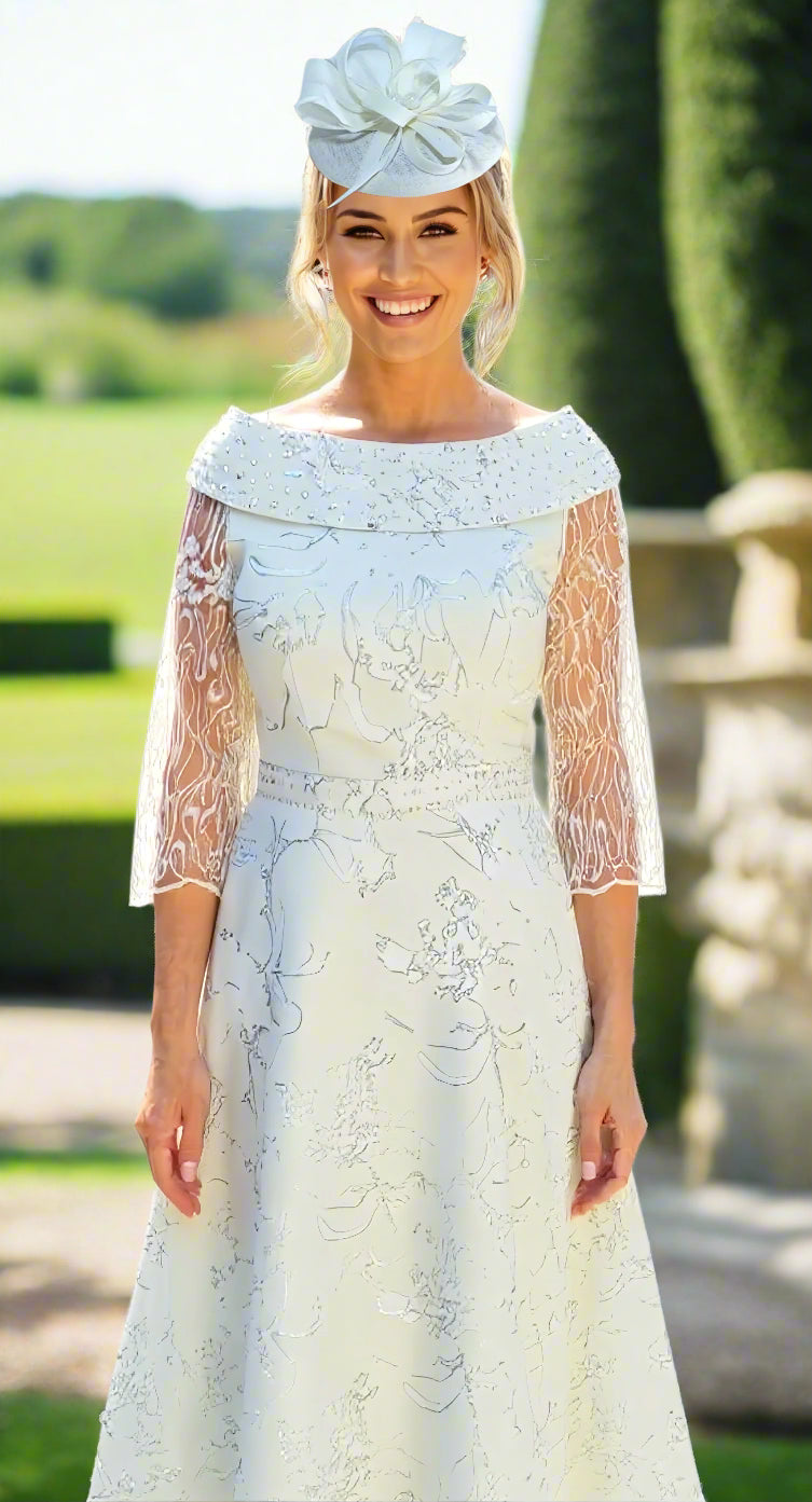 Woman wearing a mint green lace dress with long sleeves and a matching head piece at a wedding