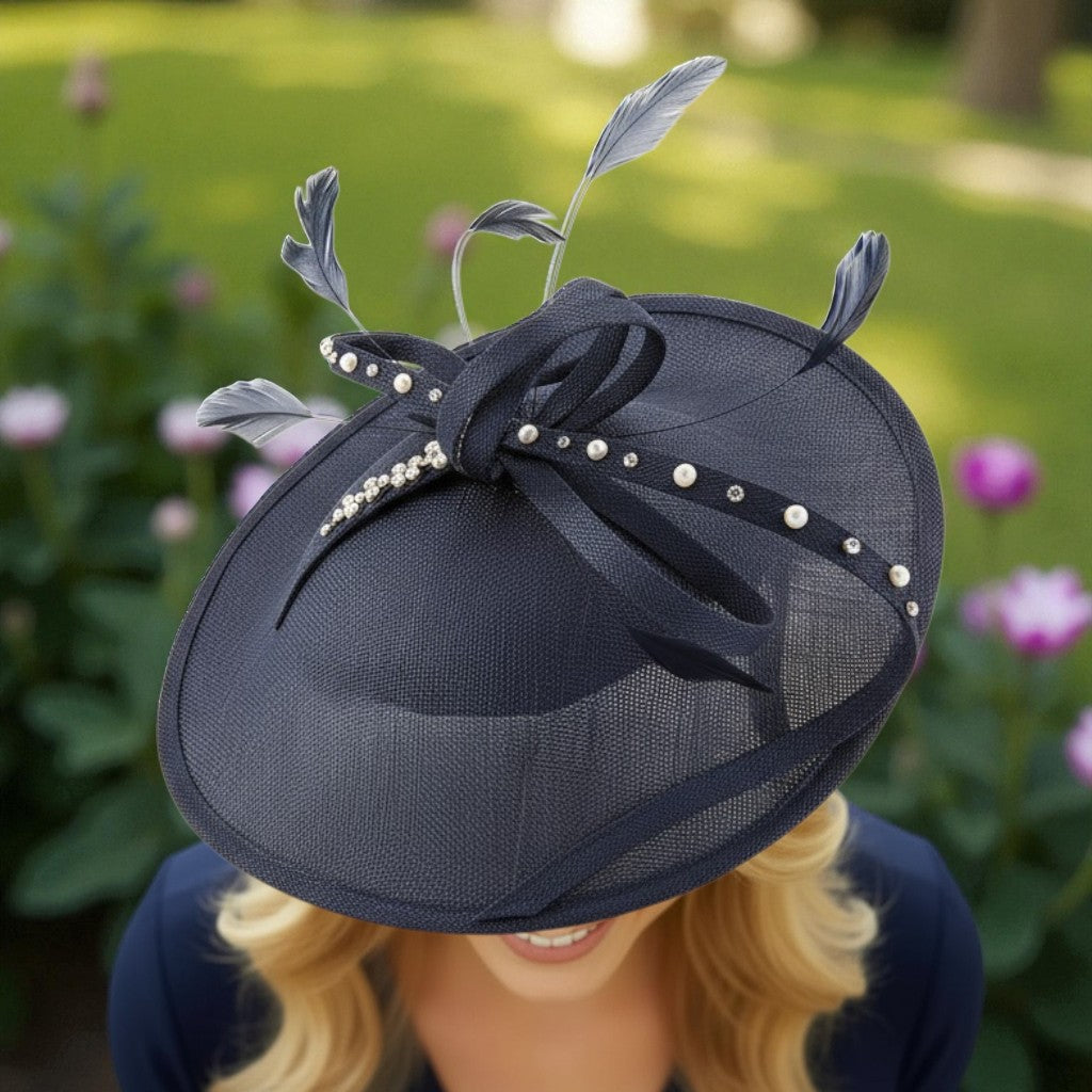 Navy fascinator embellished with feathers and pearls against a blurred garden background
