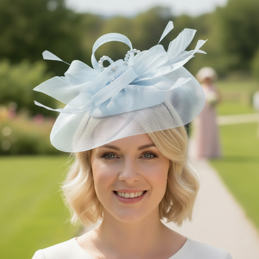 Woman wearing a light blue fascinator that has embellishments and a bespoke finish. Made by Signature Dress