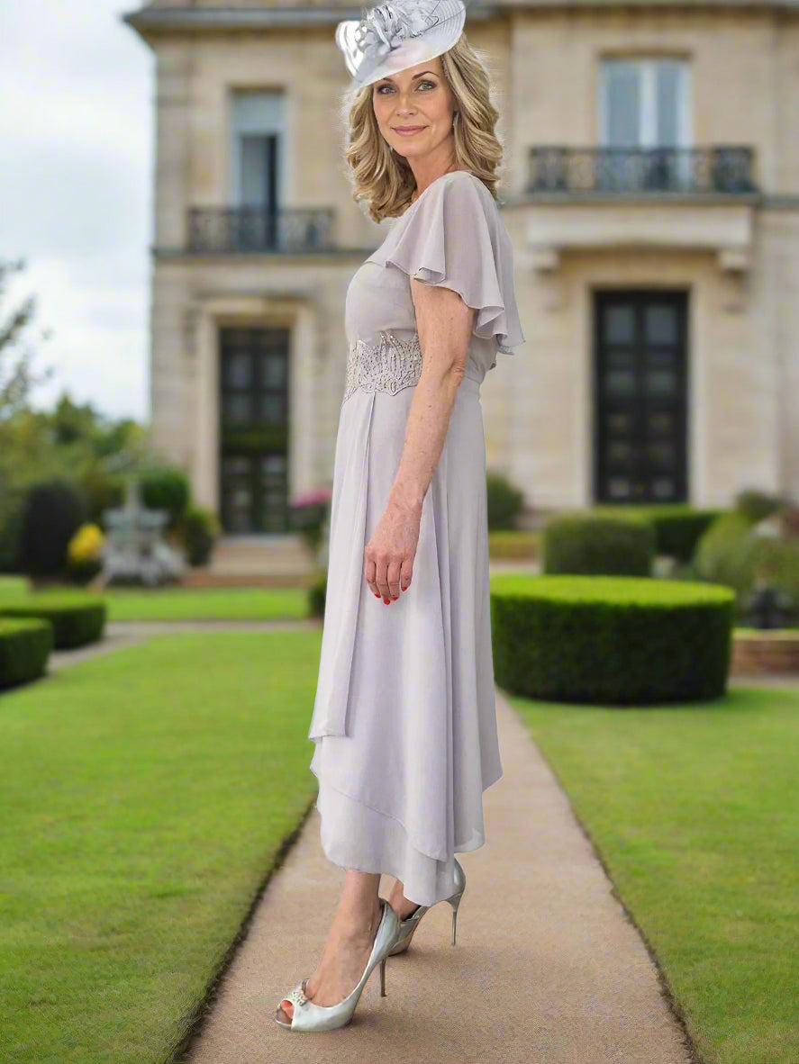 Mother Of The Bride beautiful chiffon dress by Lizabella, is a fit with slight flare and a attached cape looking sleeve, concealed zip to the back and lined, finished with embellished beads to the centre front.