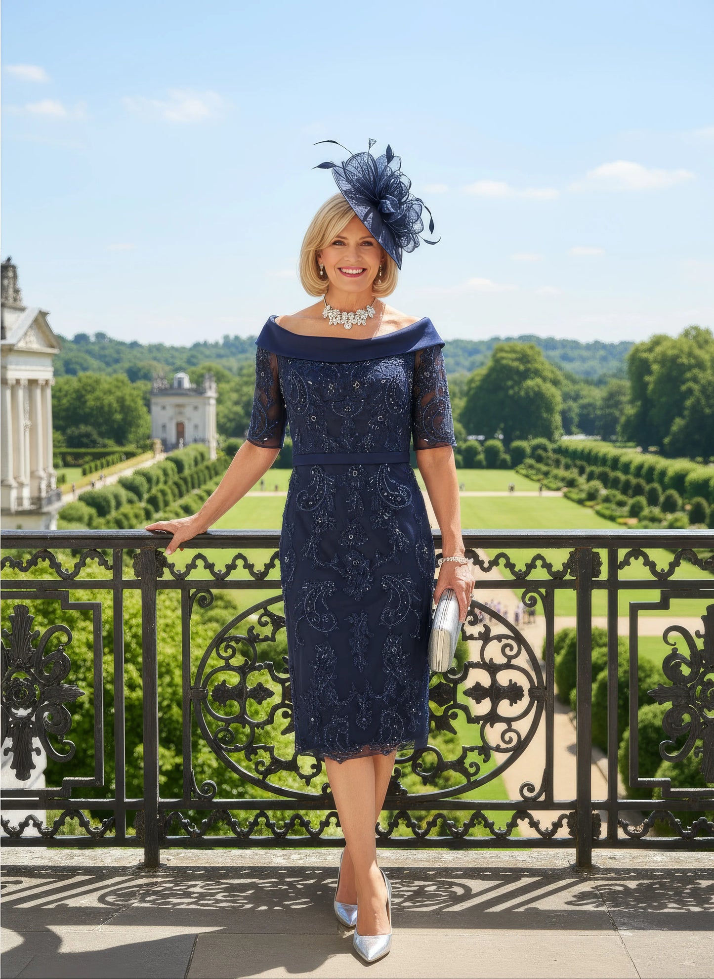 Woman in a navy Veni Infantino dress with lace details standing on a balcony with a scenic background