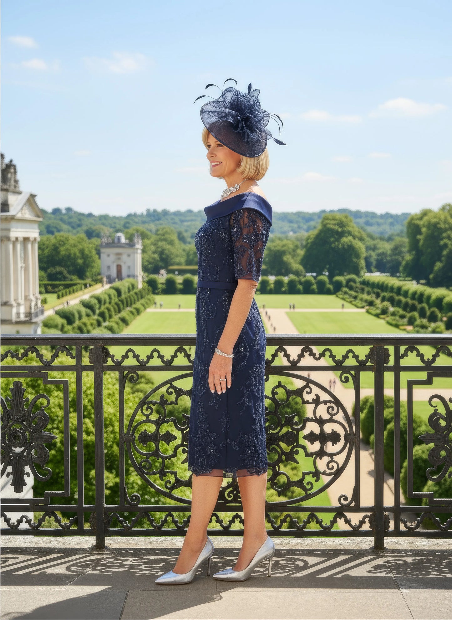 Woman in a navy Veni Infantino dress with lace details standing on a balcony with a scenic background