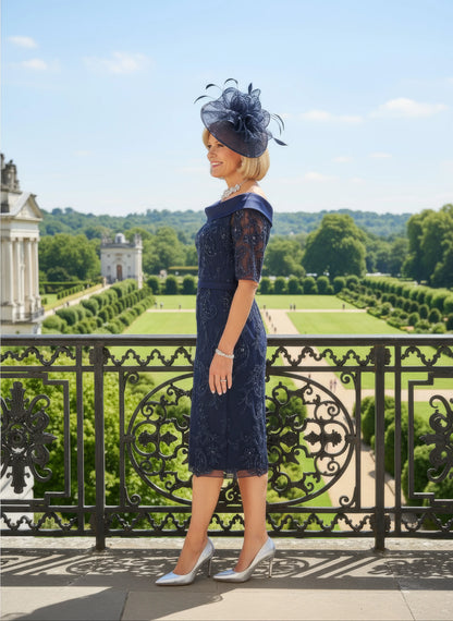 Woman in a navy Veni Infantino dress with lace details standing on a balcony with a scenic background