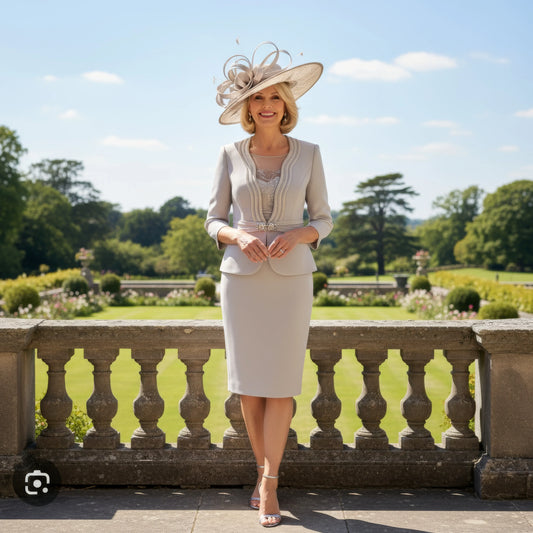 Woman in formal attire veni infantino dress suit in pale taupe with a hat standing in a garden setting