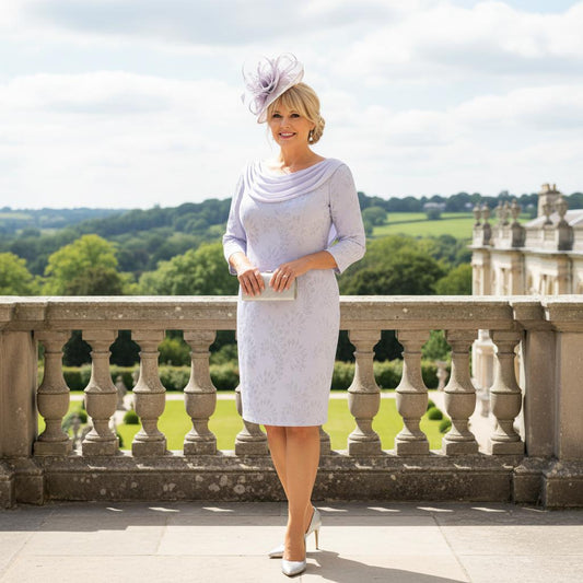 Woman in a lilac veromia mother of the bride dress standing on a balcony with a scenic background. Signature Dress.
