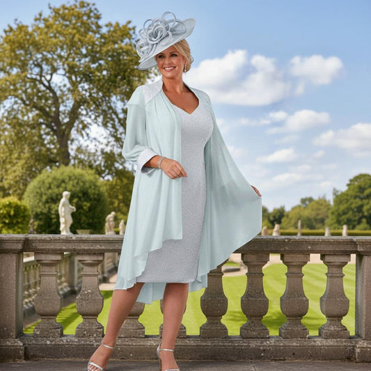 Woman in a plus size veromia light blue dress and jacket and mtaching pale blue fascinator standing on a hotel balcony ready for a wedding. Signature Dress.