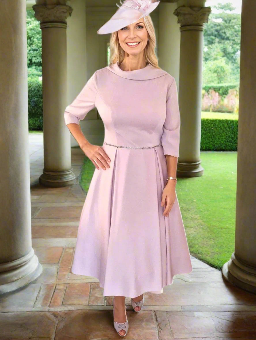 Veromia Mother of the Bride dress is elegantly crafted with a beautiful pink hue, midi length, 3/4 sleeves, and a full net skirt for a 50's aline silhouette.