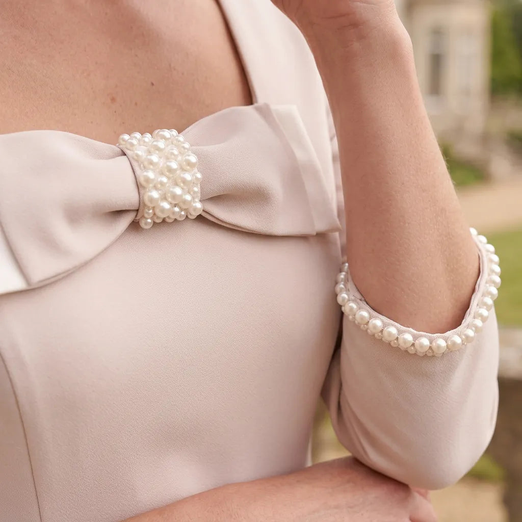 Close-up of the pearl embellished bow and square neckline on the beige Lizabella 2814 dress