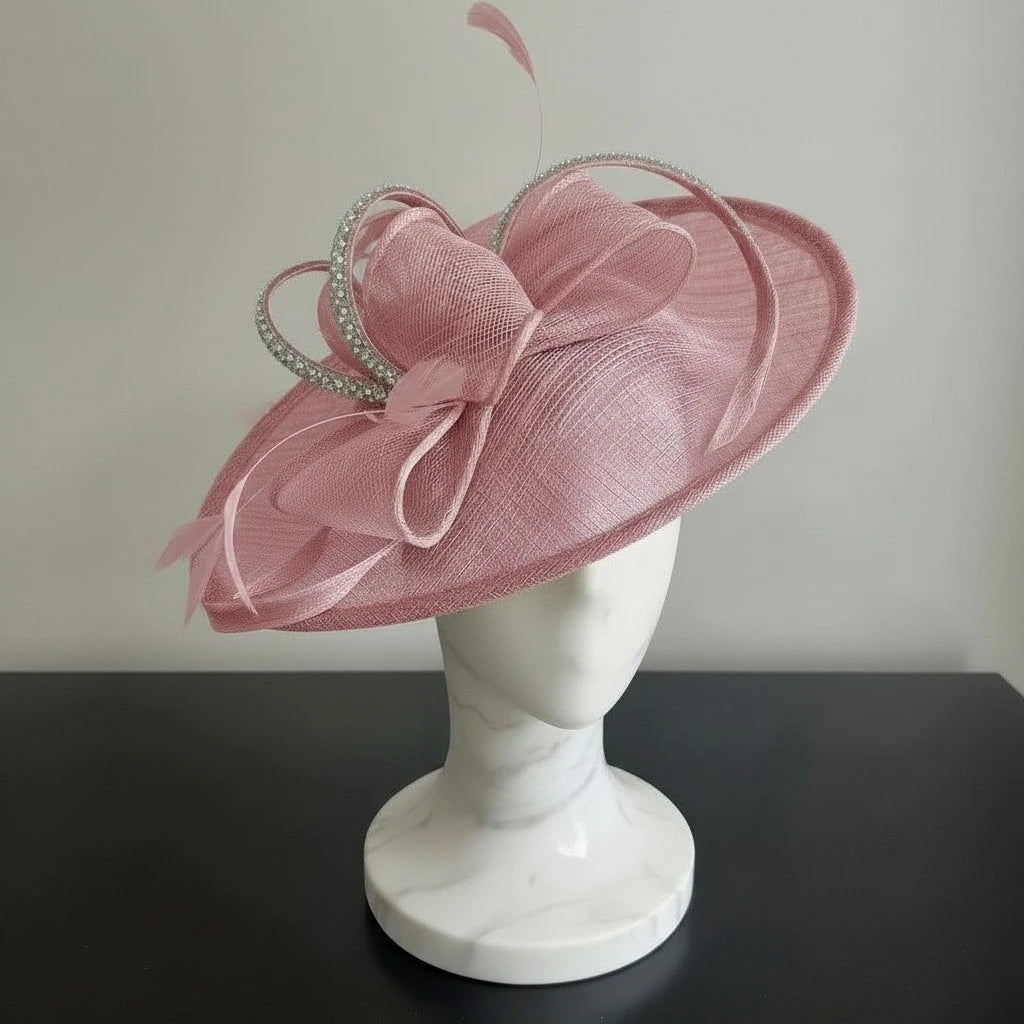 Pink decorative hat on a mannequin head against a plain background