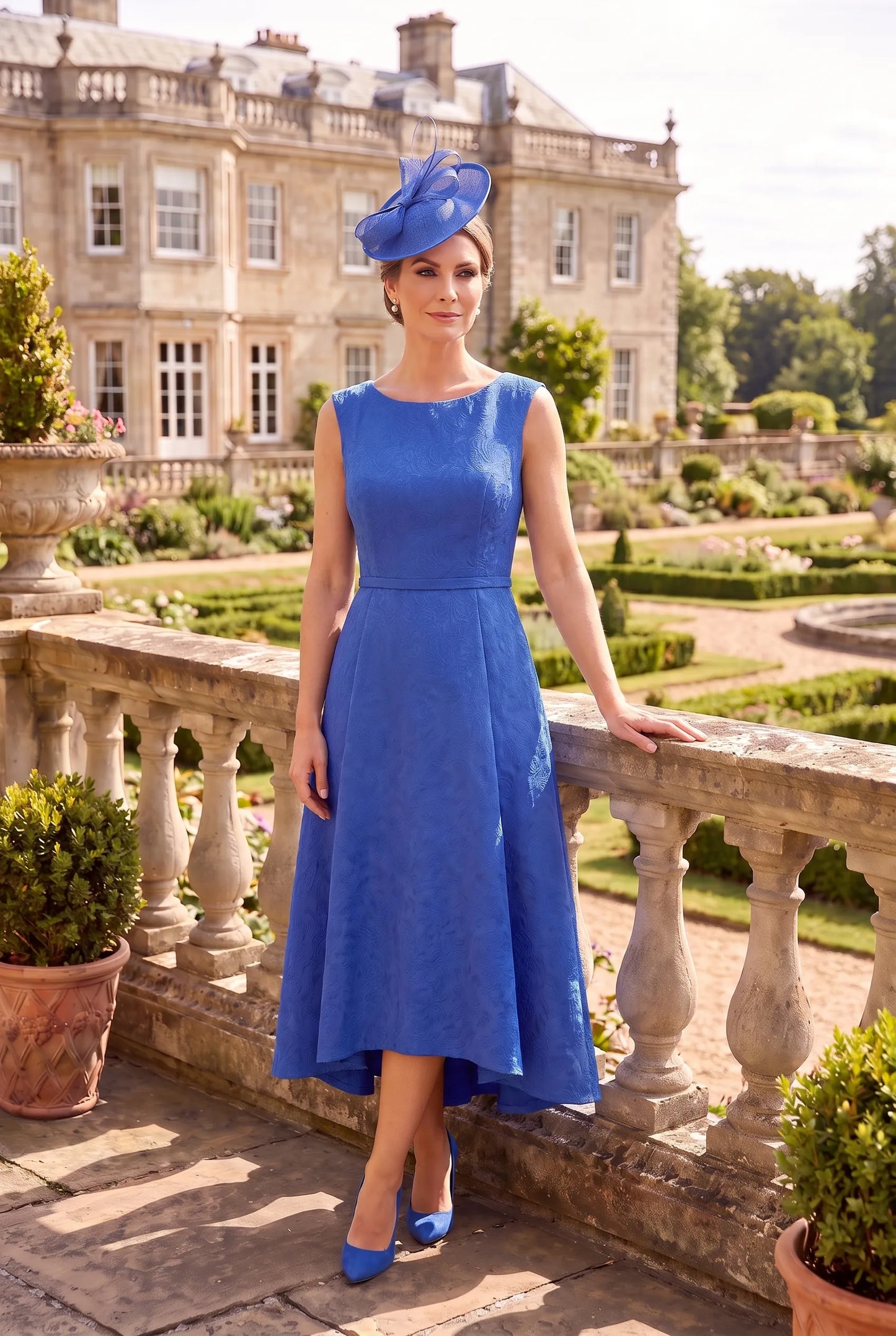 Sleeveless Blue Mother of the Bride Dress by Rosa Clará Couture Club 3G2B0 showing the flattering fitted silhouette and high-low hem.