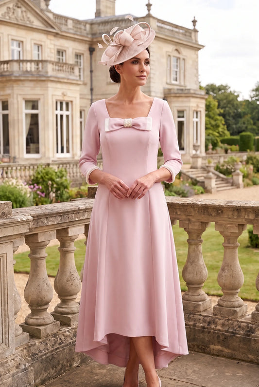 Blush pink Mother of the Bride dress by Lizabella 2814 with pearl embellished bow and dipped hem