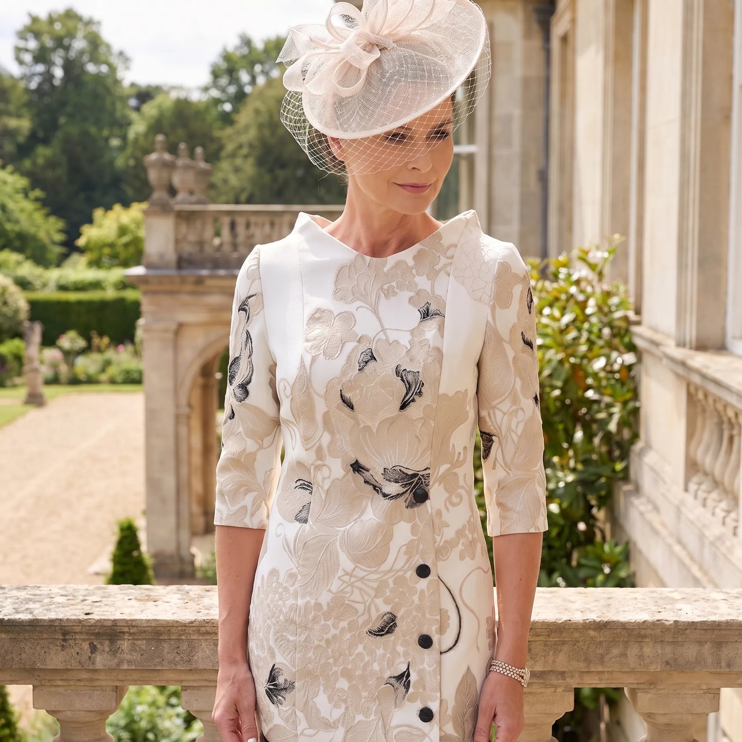 Close-up of the Fely Campo 21332 Champagne Mother of the Bride dress showing the mandarin-style neckline and beautiful floral jacquard detailing.