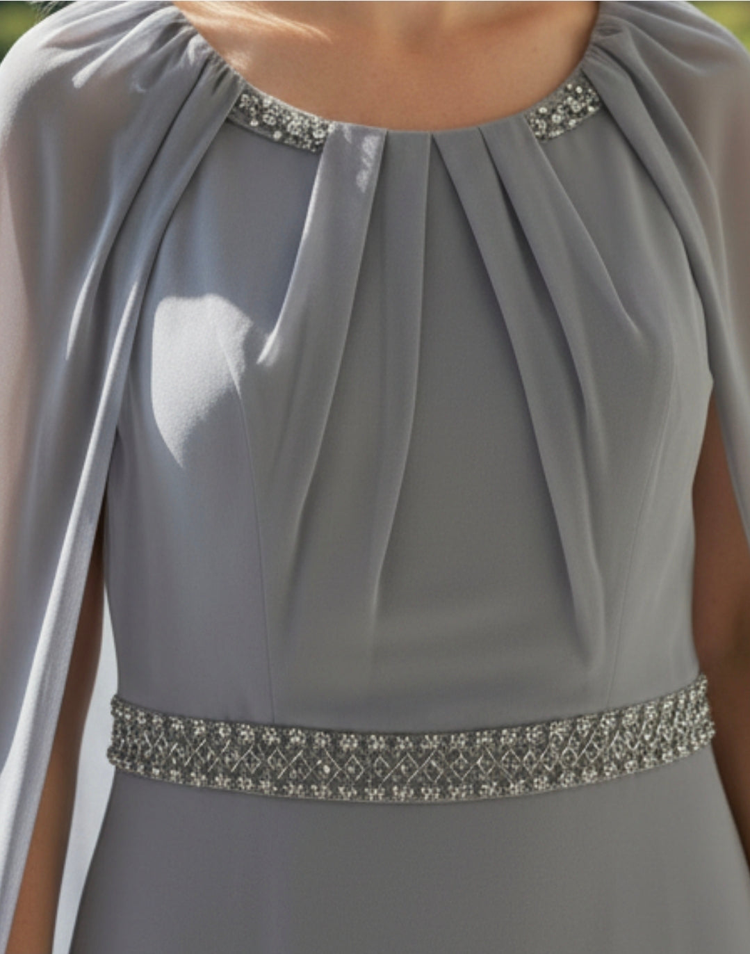 Closeâ€‘up of the Rosa Clara Couture Club 8G151 blueâ€‘grey mother of the bride dress showing the pleated bodice, embellished neckline and detailed waist beading.