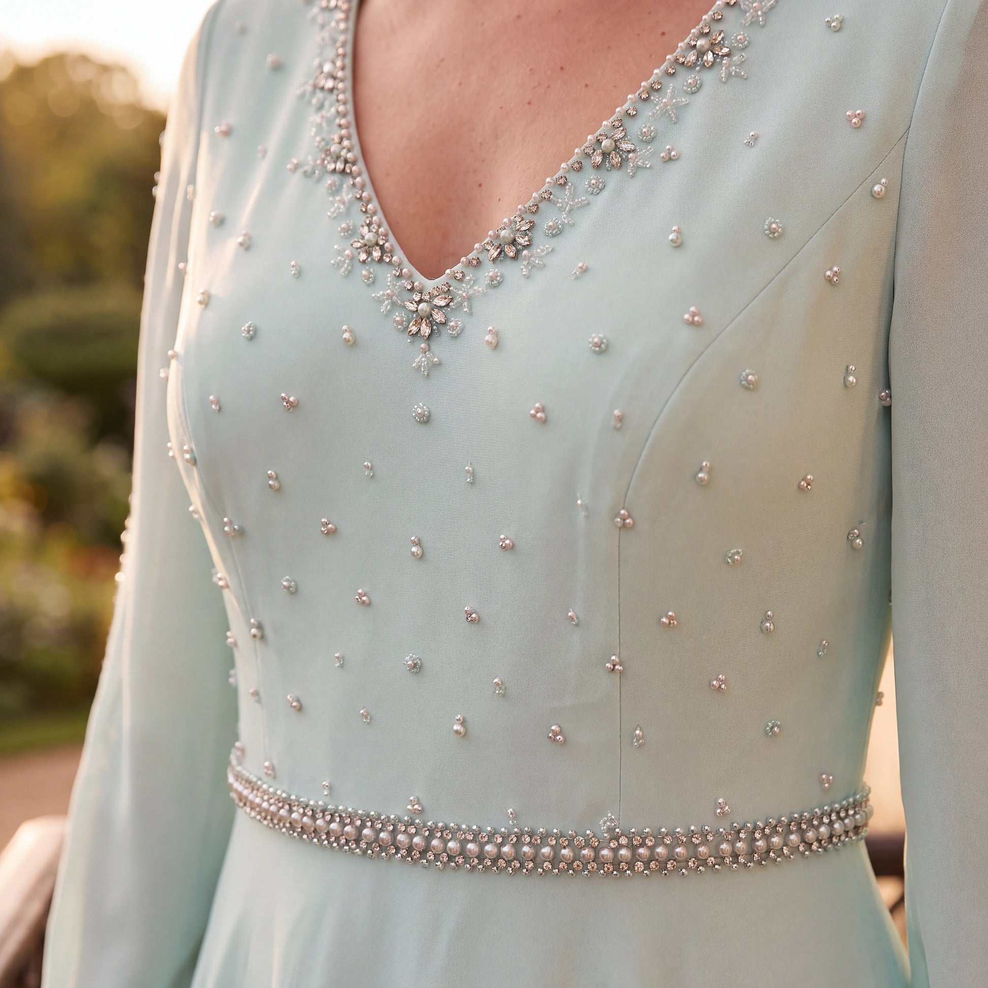 Close-up of the Couture Club 7G1C8 Green Mother of the Bride Dress showing the pearl and crystal embellished neckline, bodice and waist detailing.