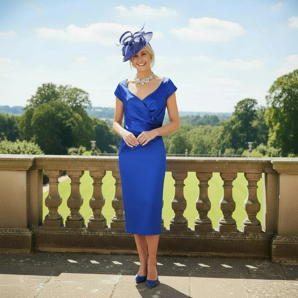 Woman in a cobalt blue ispirato mother of the bride dress with a sweetheart neckline and bespoke fascinator as Mother of the Bride - Signature Dress
