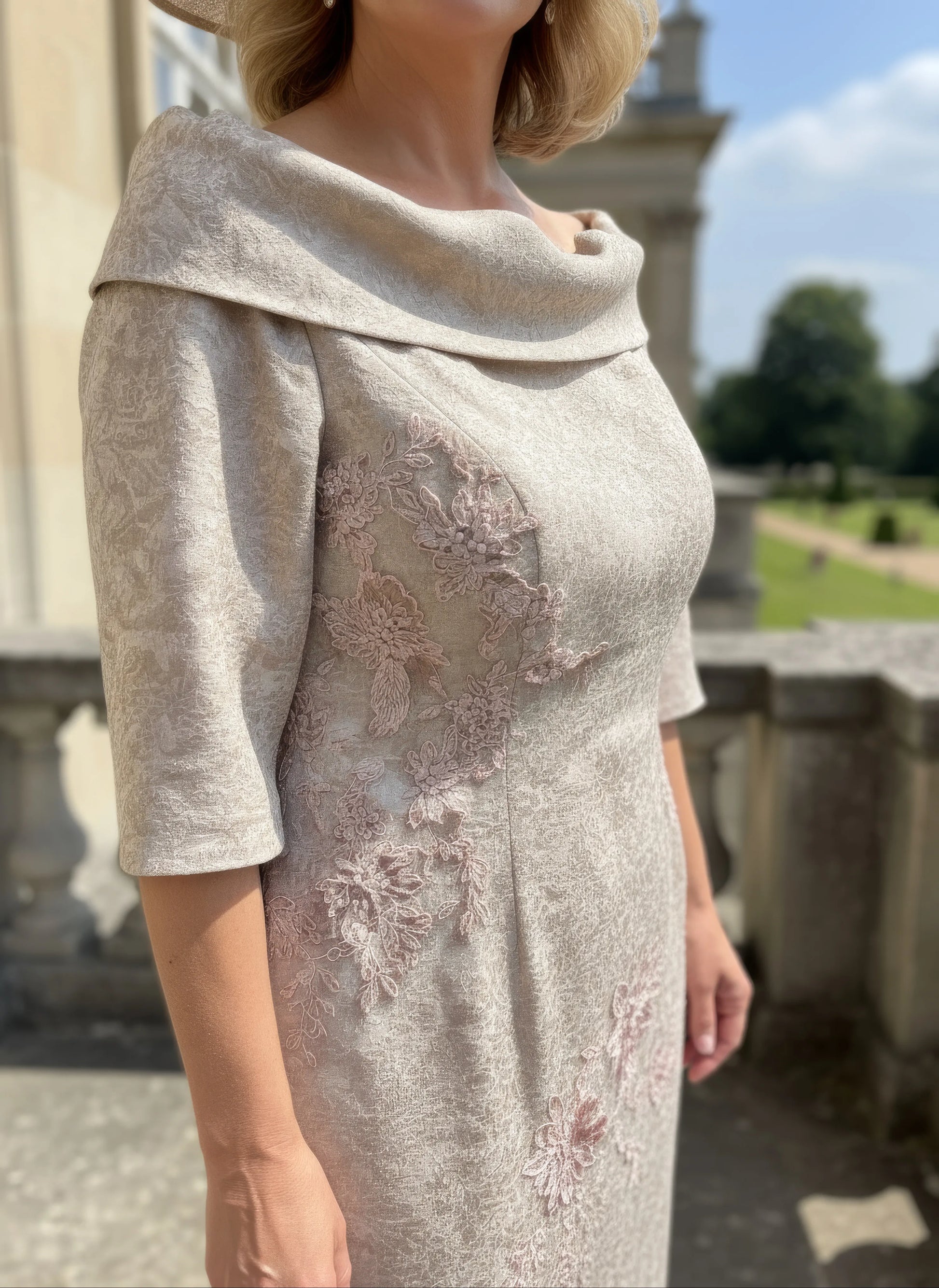 Woman wearing a beige john charles embroidered dress as mother of the bride - signature dress.