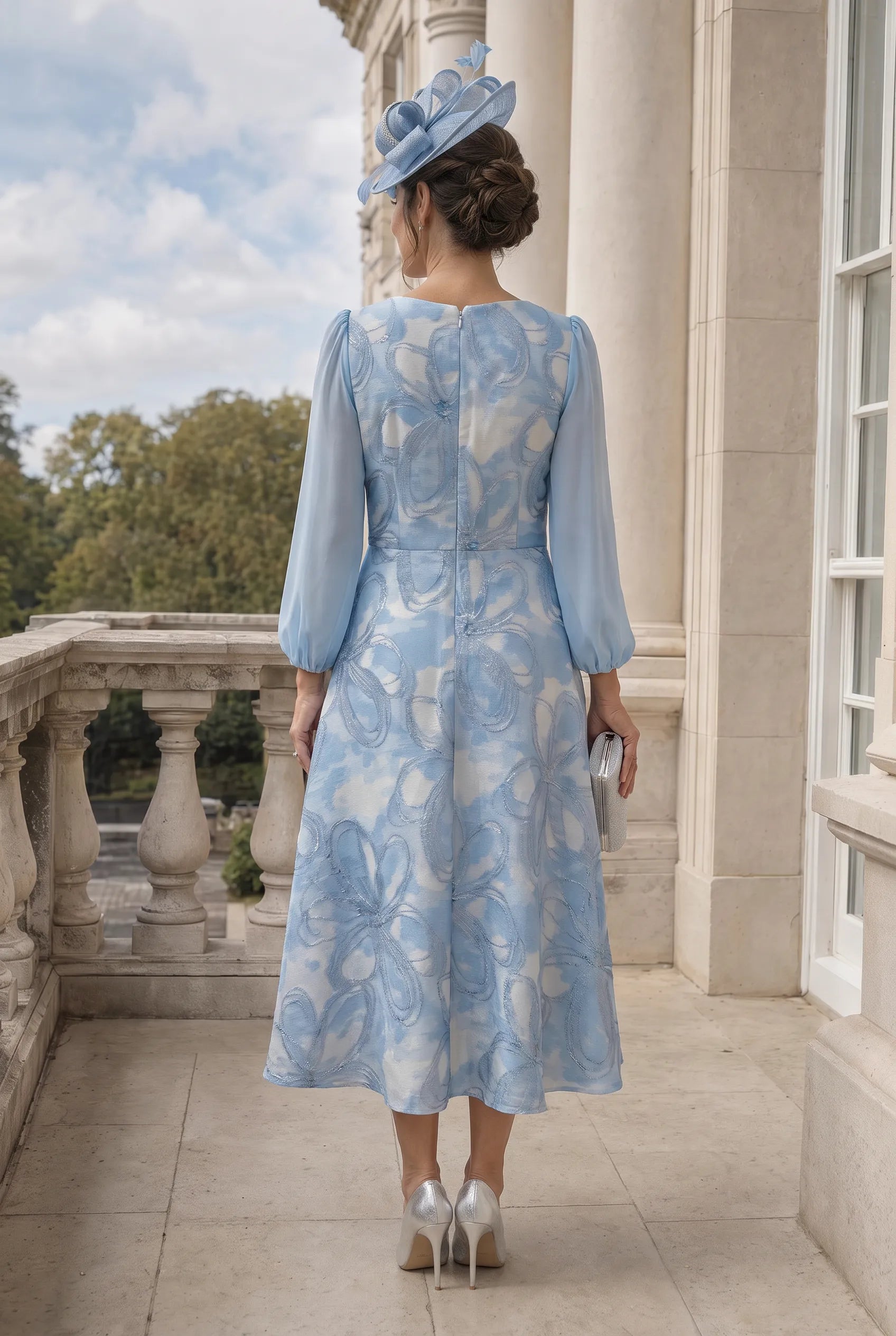 Back view of Lizabella 2834 light blue Mother of the Bride dress with flowing midi skirt