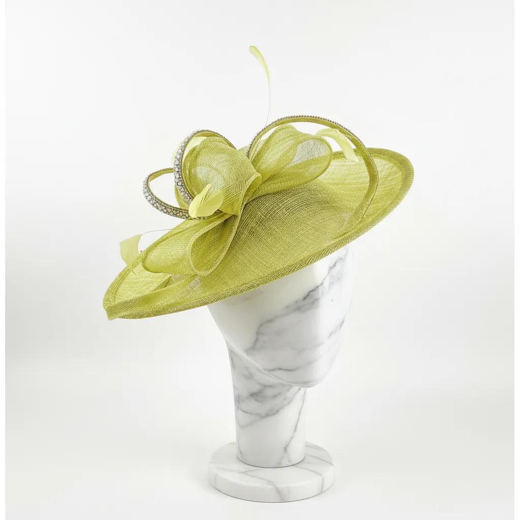 Green decorative  fascinator embellished hat on a white marble stand with a white background