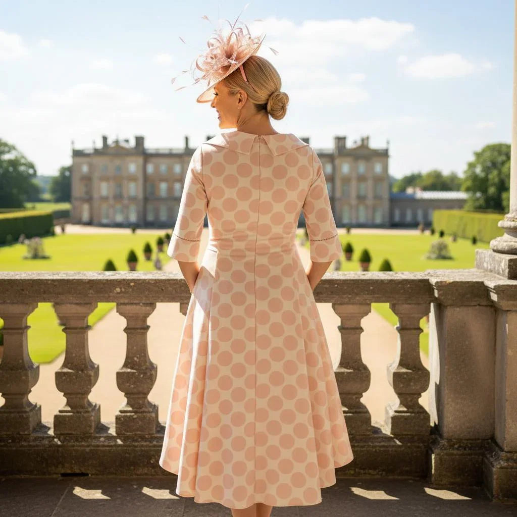 Woman in a Lizabella 2269 pink Mother of the Bride dress with elegant polka dot print, full skirt, half sleeves and concealed side