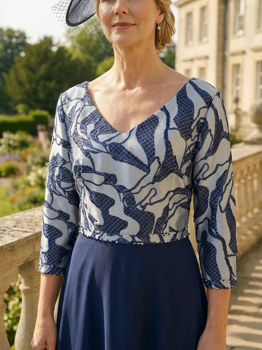 Close-up of the Lizabella 2513 navy mother of the bride dress showing pearls and rhinestones at the cuffs and waist.