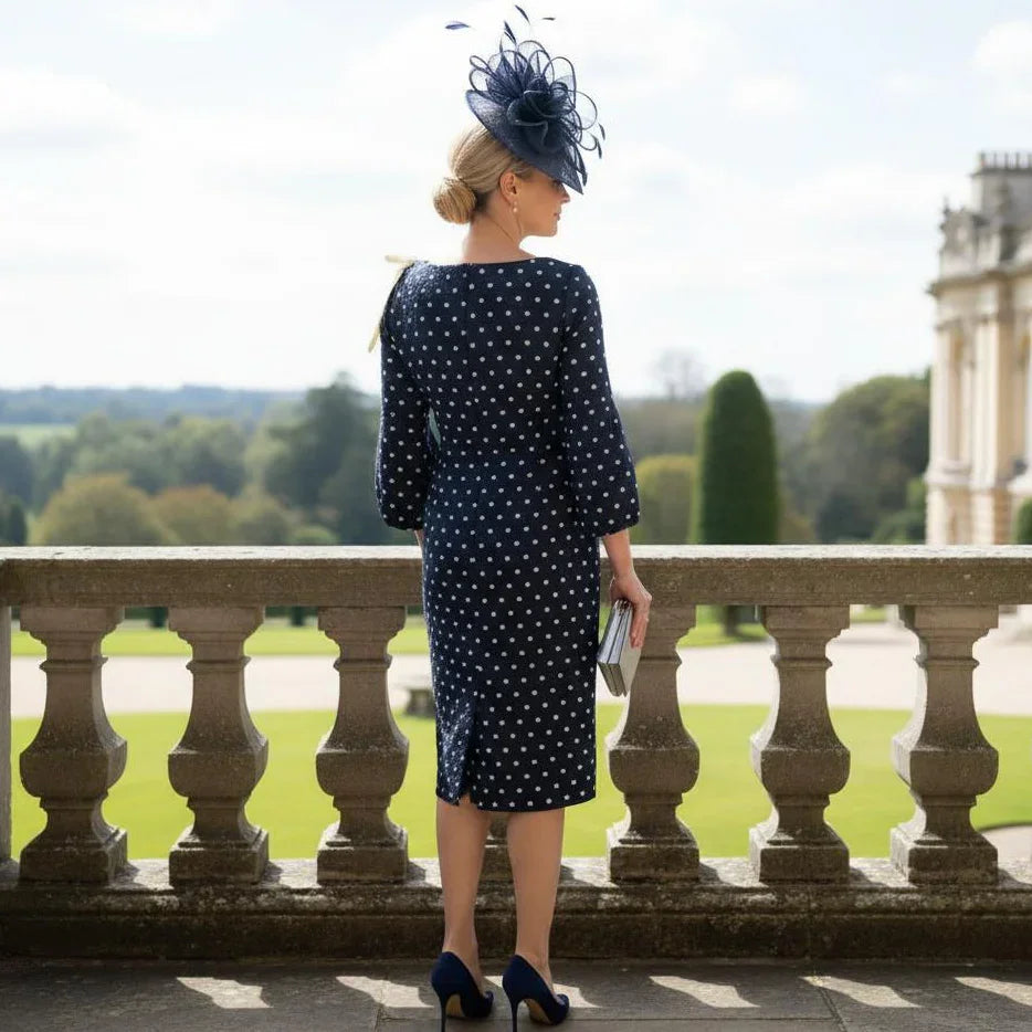 back view of a Lizabella 2548 navy Mother of the Bride dress with polka dot fabric, bow shoulder detail and boat neckline.
