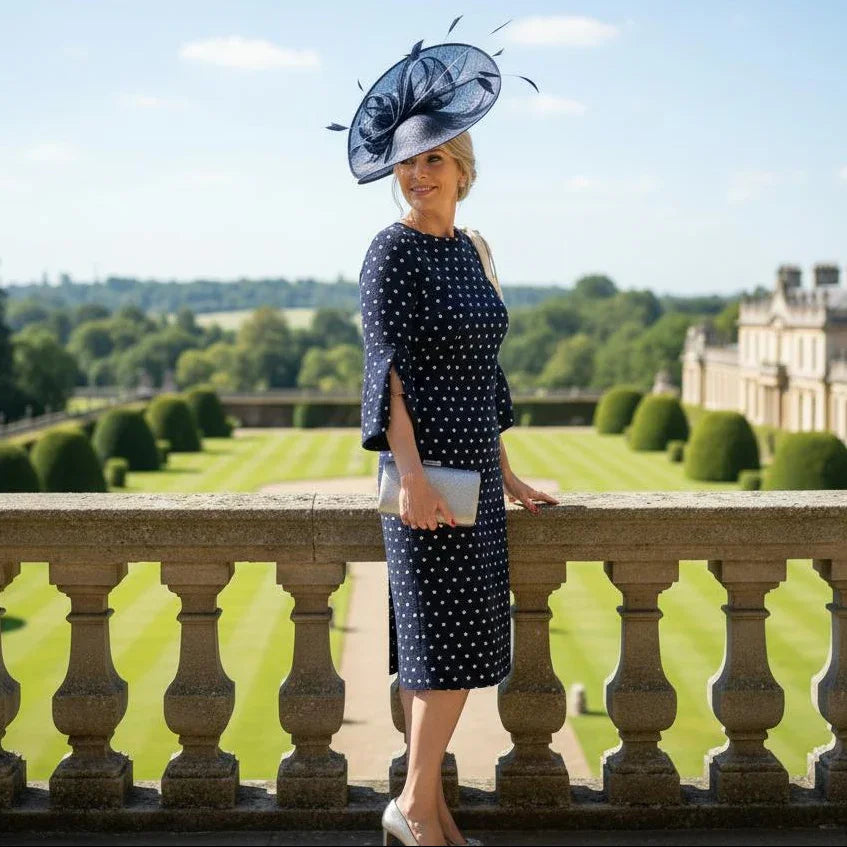 side view of a Lizabella 2548 navy Mother of the Bride dress with polka dot fabric, bow shoulder detail and boat neckline.Lizabella 2548 navy Mother of the Bride dress with polka dot fabric, bow shoulder detail and boat neckline.