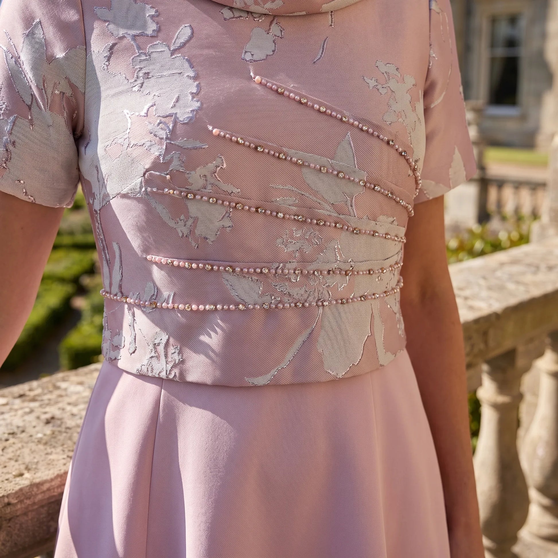 Close-up of the floral jacquard bodice and pearl waist detail on the Lizabella 2988-02 pink dress