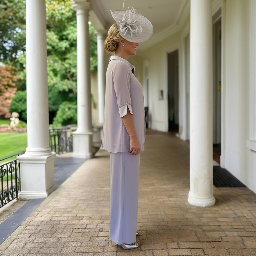 Lizabella silver chiffon trouser suit 7231 with beaded neckline and matching hat, photographed on a columned terrace.