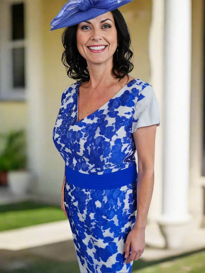 Woman wearing a blue and white floral dress with a matching hat on a white background