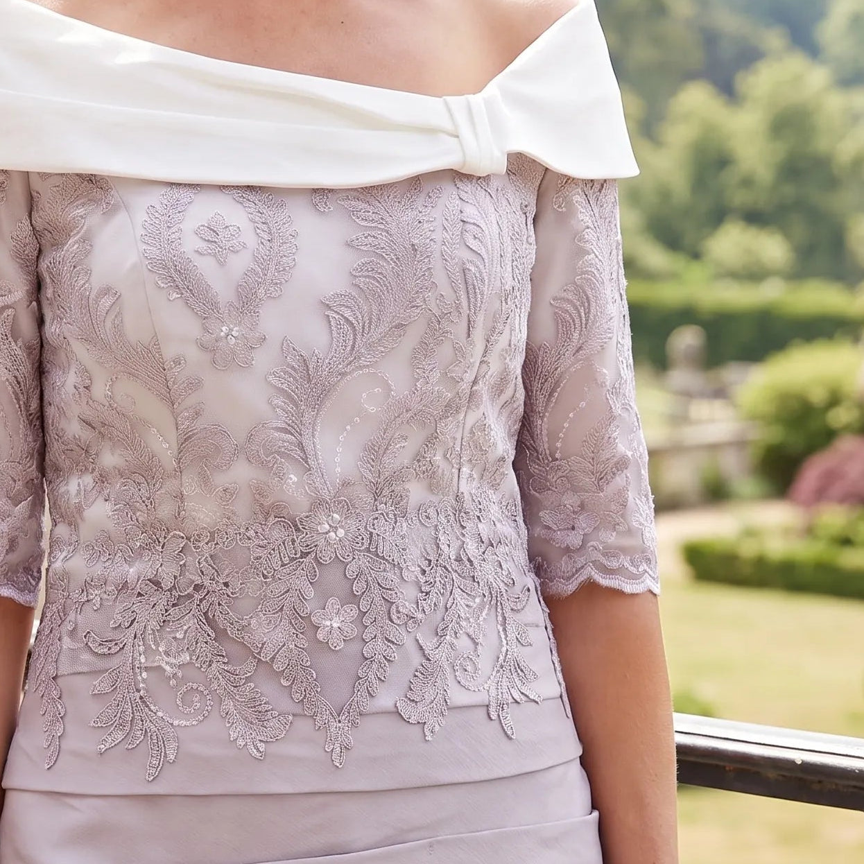Close-up of the Ispirato ISJ814 Mauve Mother of the Bride dress showing the intricate ivory floral lace bodice and elegant Bardot neckline.