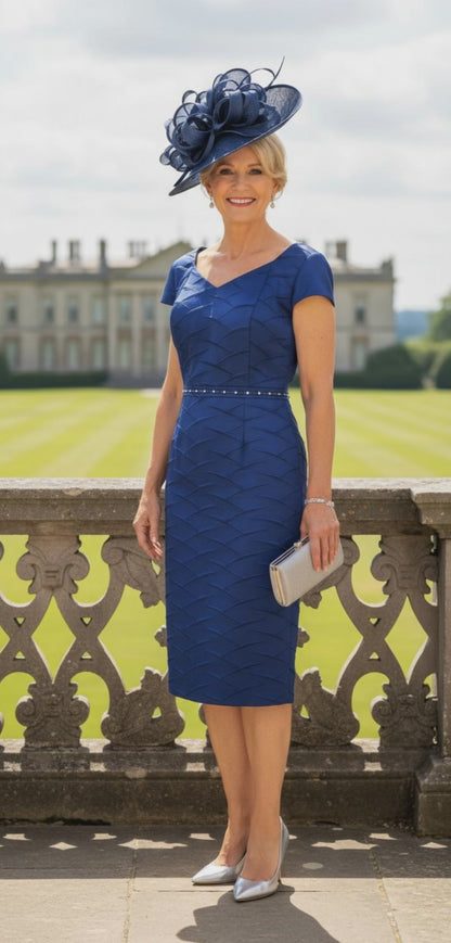 Woman in a COBALT blue LIZABELLA dress with a matching hat standing outdoors. Signature Dress