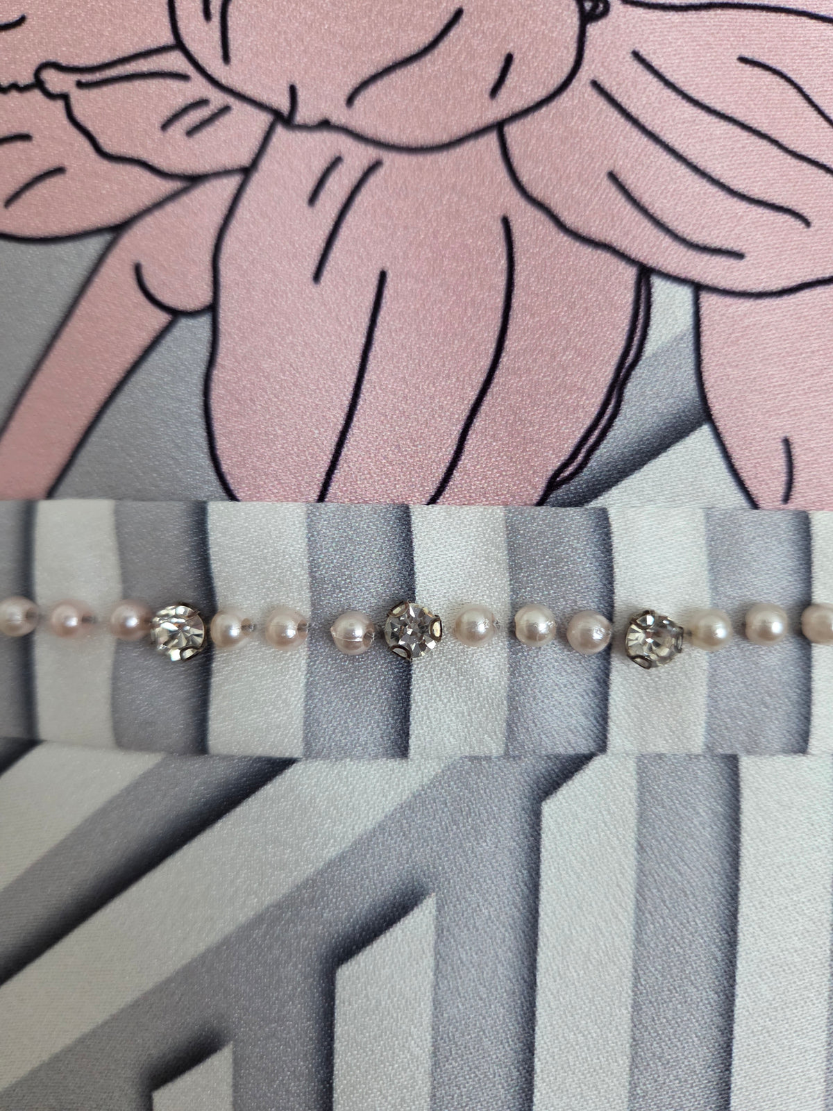 Close-up of the Lizabella 1195 silver Mother of the Bride dress showing its embellished waistband, pink floral print and geometric stripes